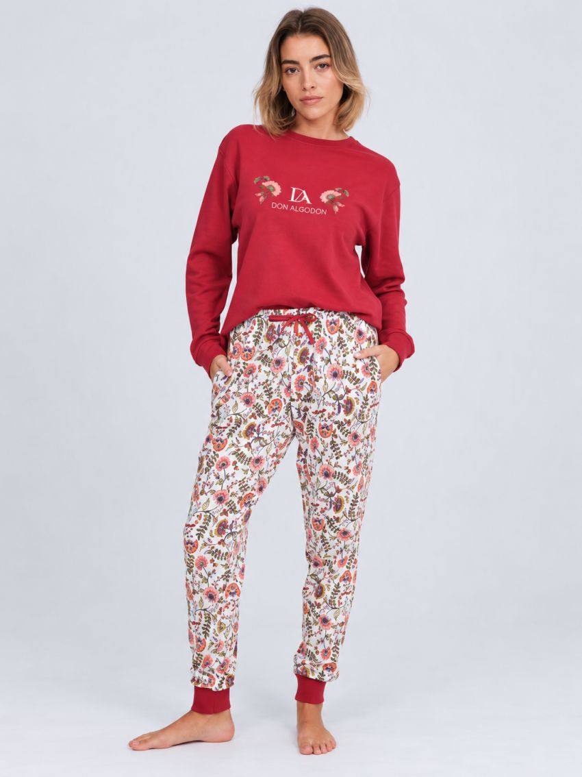Modelo con pijama de mujer Don Algodón DA26W413, camiseta roja de manga larga y pantalón floral claro con puños rojos.