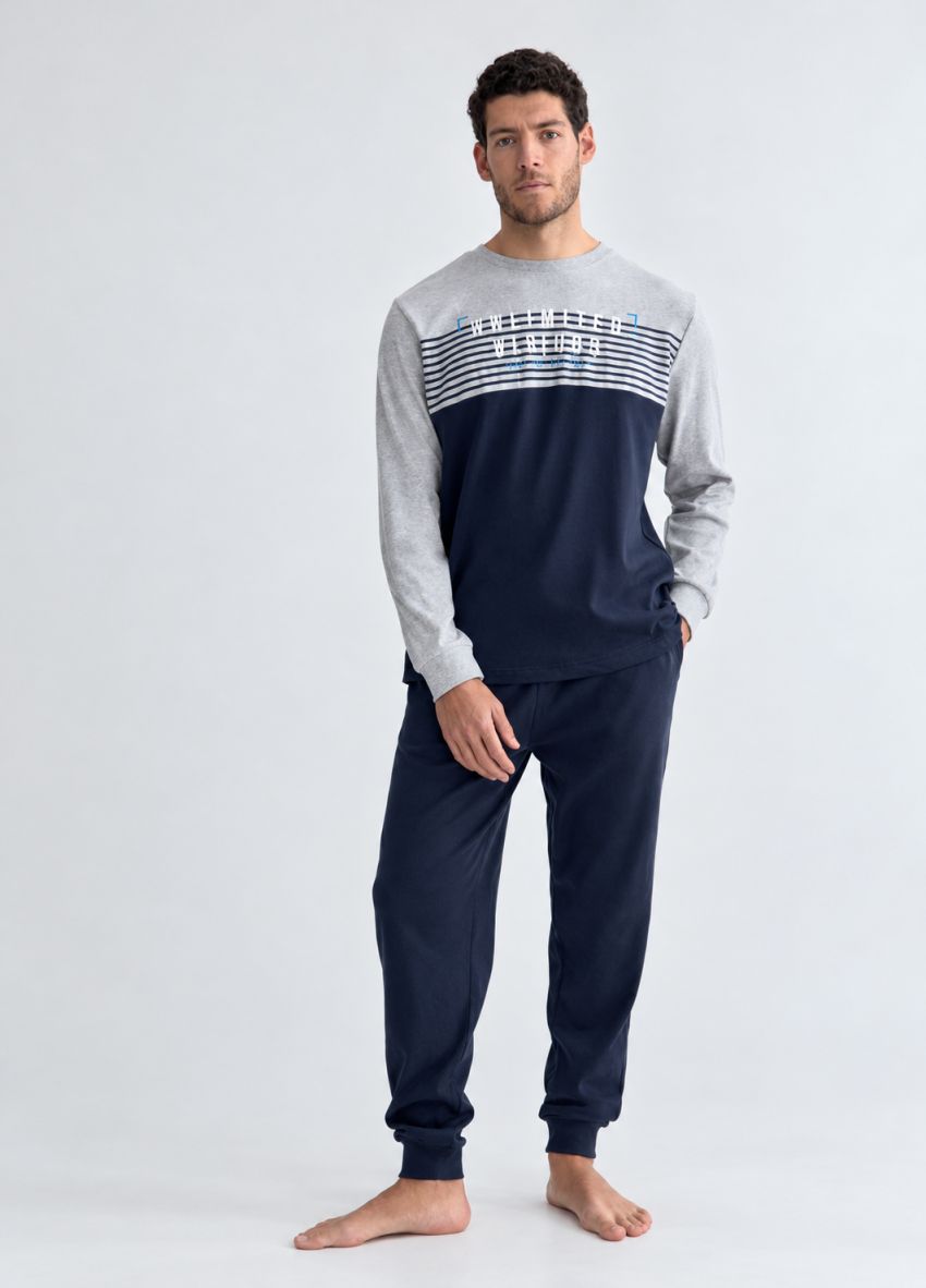 Pijama de hombre con camiseta de manga larga gris y azul marino con rayas en el pecho y pantalón azul marino con puños.
