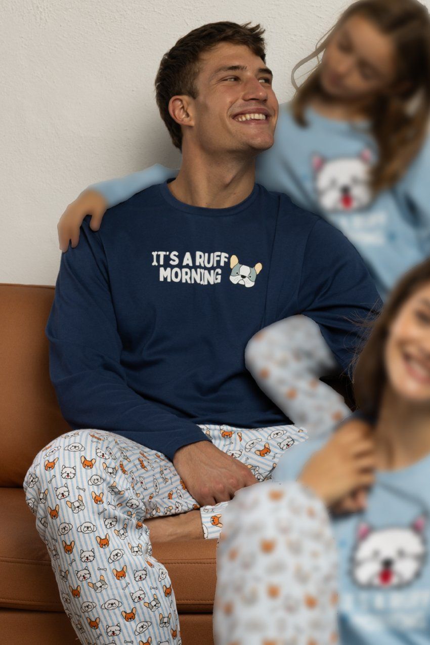 Modelo con pijama de hombre Admas Ruff Morning 64801, con camiseta azul de manga larga y pantalón claro estampado con motivos de perros.