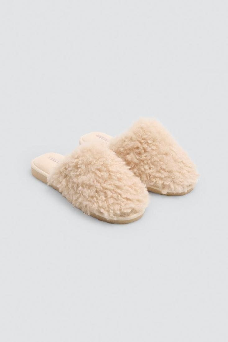 Zapatillas de casa para mujer Ysabel Mora 14206 en tono beige claro, con acabado de pelo rizado, diseño destalonado y suela EVA.