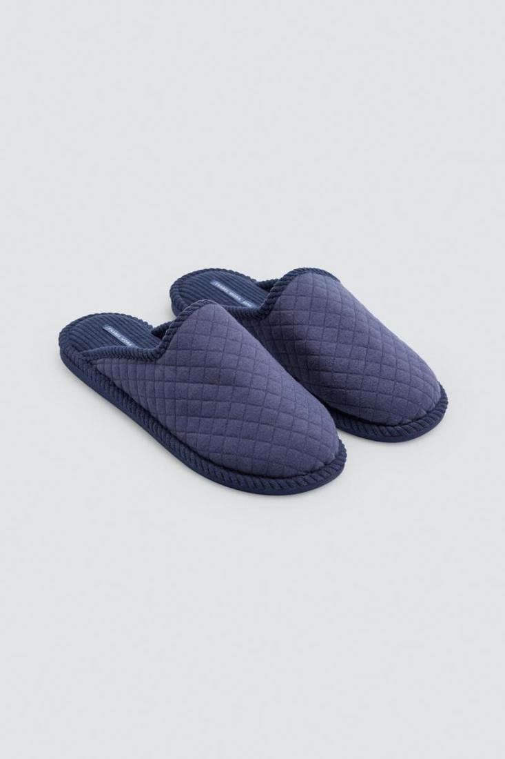 Detalle de las zapatillas de casa para hombre Ysabel Mora 24107 en azul marino, con acolchado de rombos, ribete a tono y talón abierto.