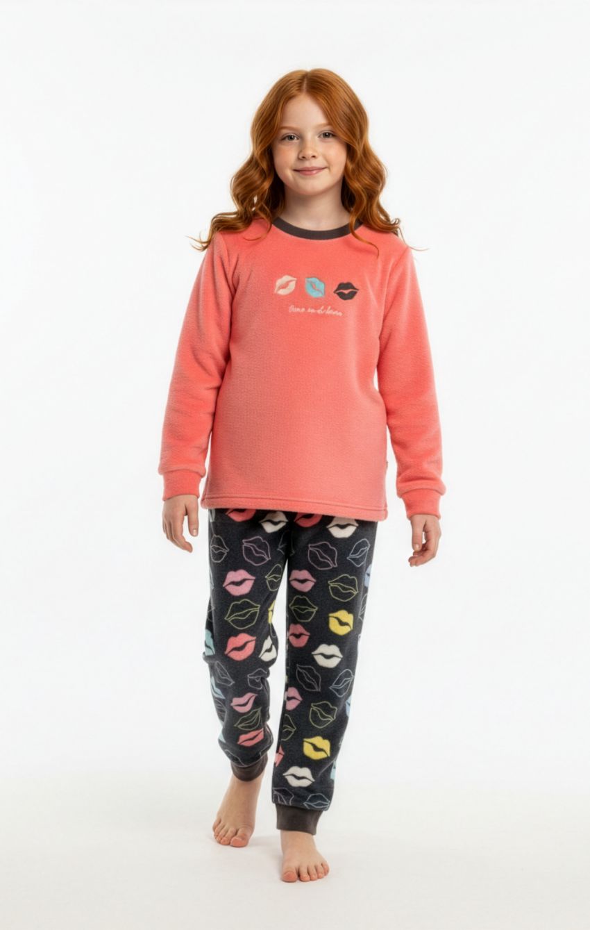 Niña con pijama de coralina KN 492, camiseta coral de manga larga con dibujos de labios y pantalón gris oscuro con labios multicolor y puños.