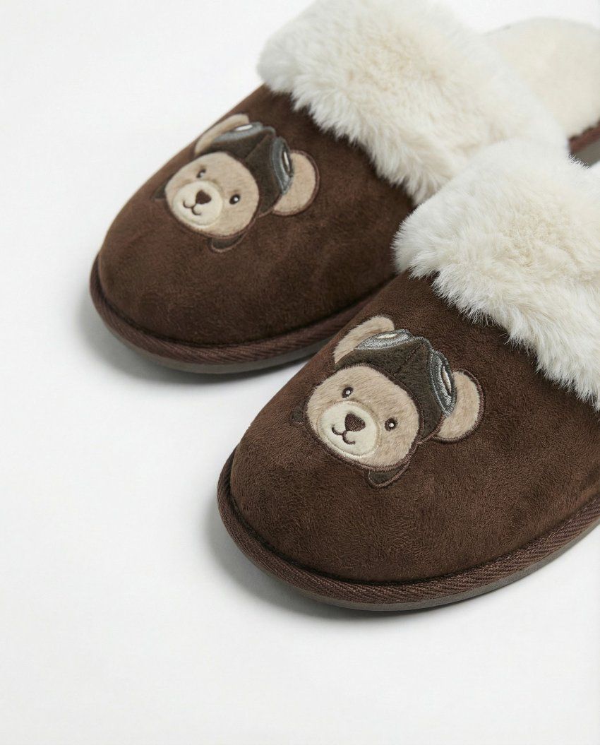mayorista Zapatillas de casa destalonadas marrones con forro de pelo blanco y aplicación de oso aviador.