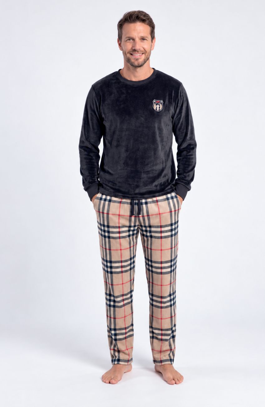Pijama de hombre con camiseta negra de manga larga y pequeño escudo en el pecho, y pantalón de cuadros beige, negros y rojos.