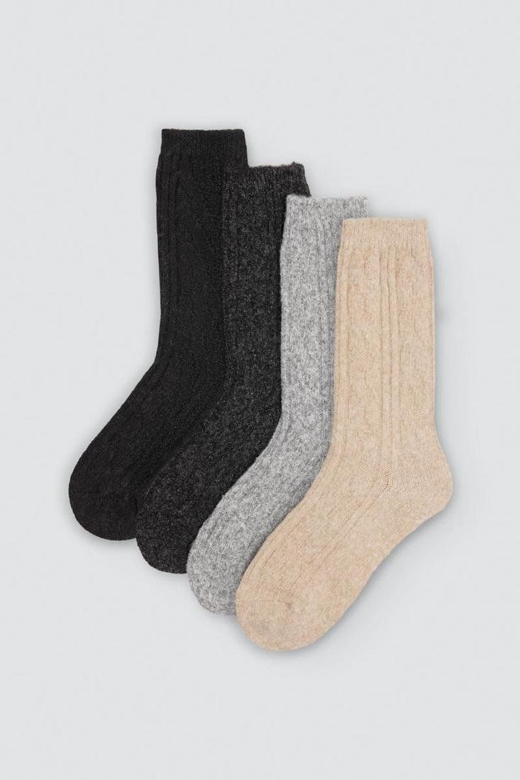 Cuatro calcetines de mujer Ysabel Mora 12147 con textura de punto en colores negro, gris oscuro, gris claro y beige.