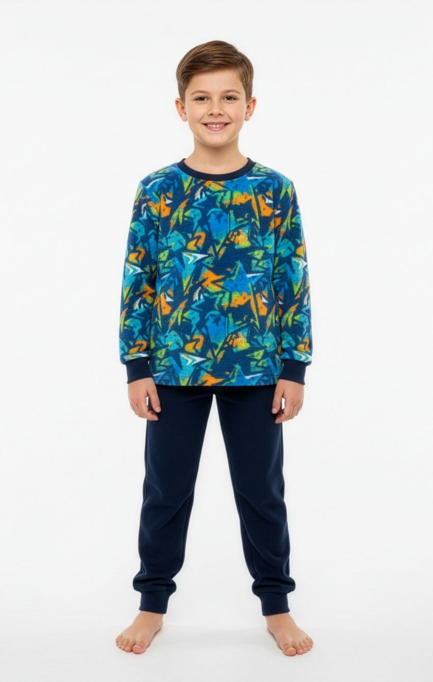 Niño con pijama de coralina KN 390, camiseta de manga larga con estampado multicolor y pantalón azul marino liso con puños.