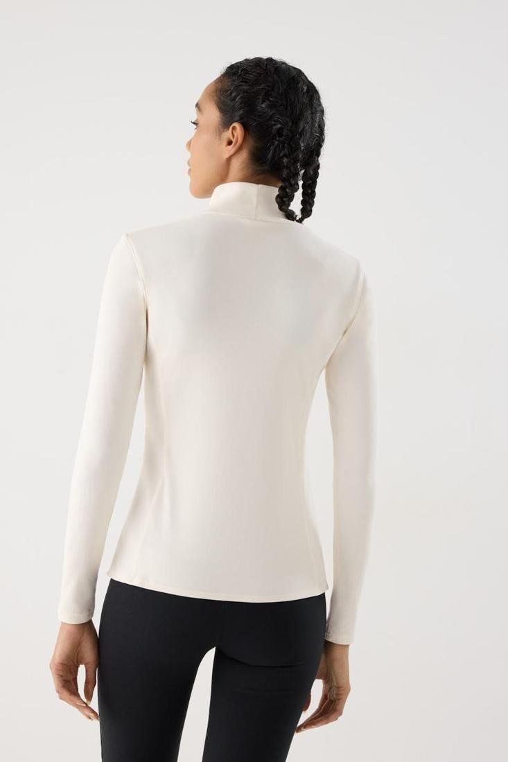 Camiseta térmica deportiva Ysabel Mora Ref. 70991 de manga larga y cuello alto, disponible en negro y crema.