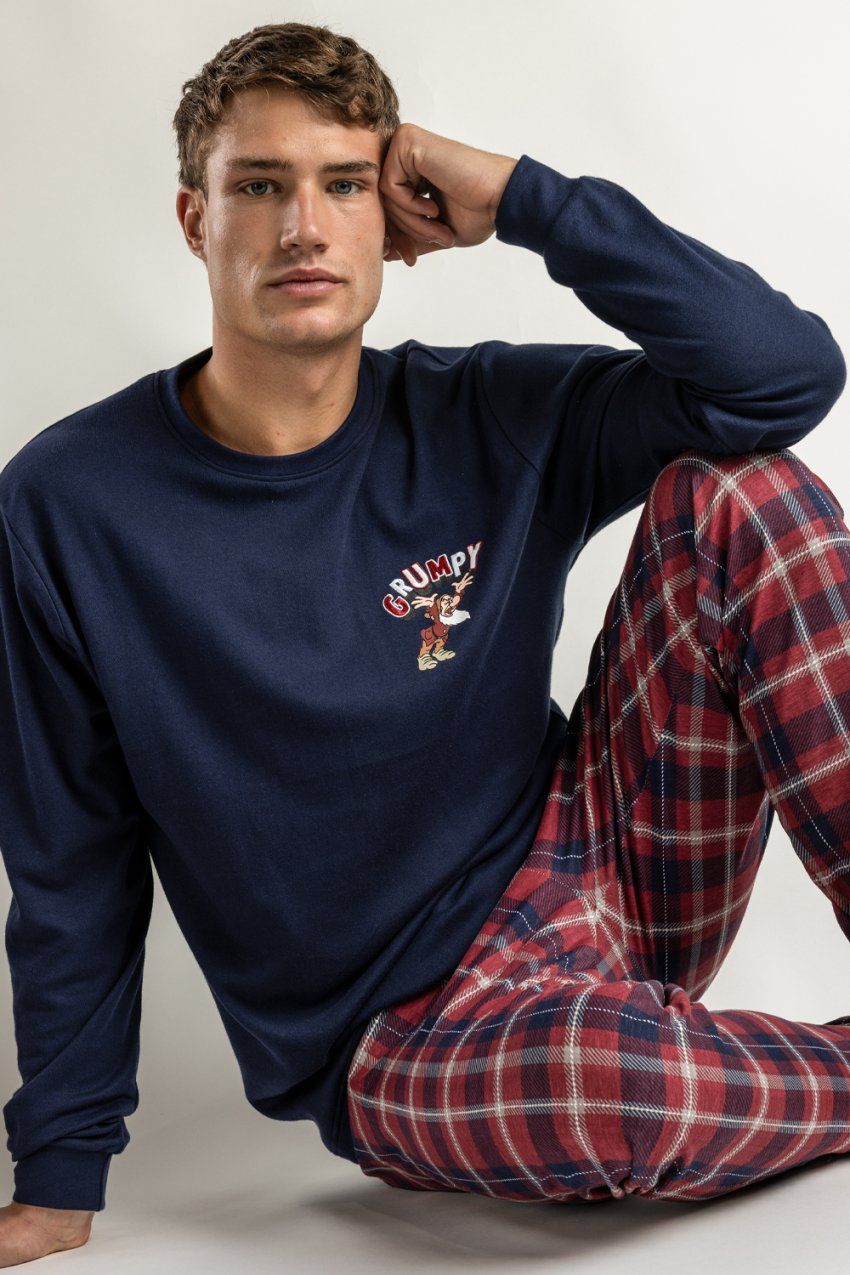 Modelo con pijama de hombre Disney Grumpy Navy 64904, con camiseta azul marino de manga larga con detalle bordado y pantalón de cuadros rojos y azules