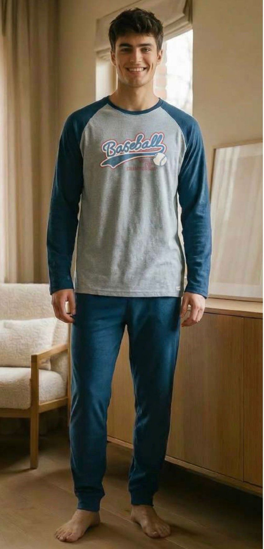 Modelo con pijama de hombre 8650, camiseta gris con mangas raglán azules y estampado de béisbol, y pantalón azul.