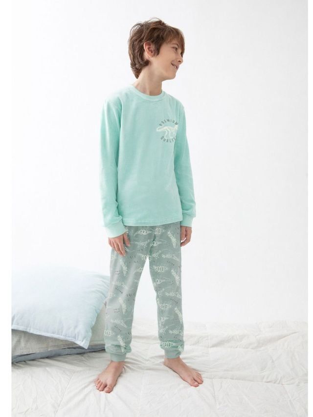Pijama de niño Katuco con camiseta verde agua de manga larga y pantalón verde grisáceo estampado con esqueletos de dinosaurios.