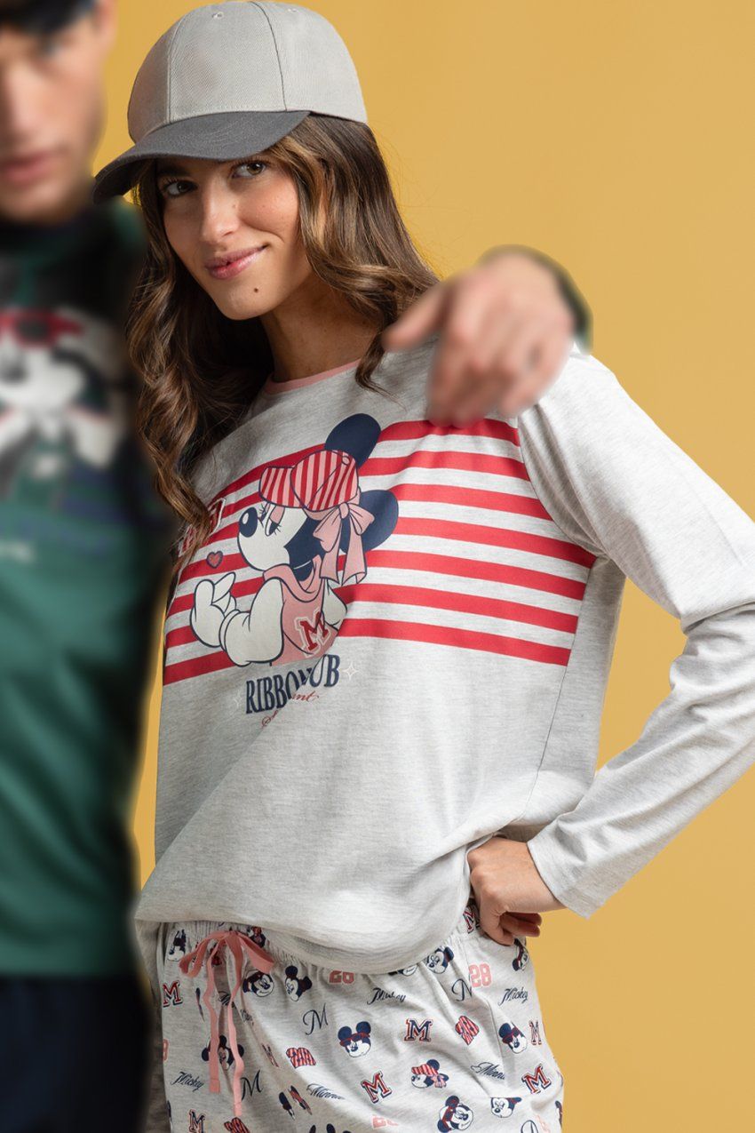 Modelo con pijama de mujer Disney Ribbon Club 64672, con camiseta gris jaspeada de manga larga con dibujo y rayas rojas, y pantalón estampado.