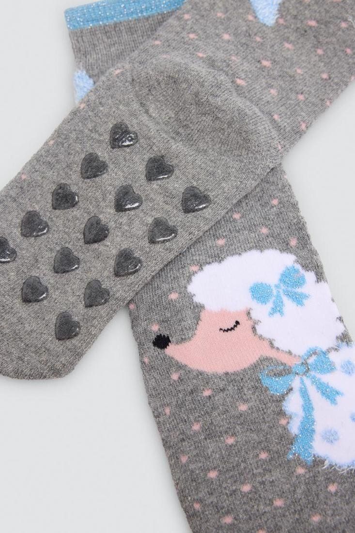 Detalle de calcetines grises de niña Ysabel Mora 32608 con dibujo de caniche, lazos azules y corazones antideslizantes en la suela.