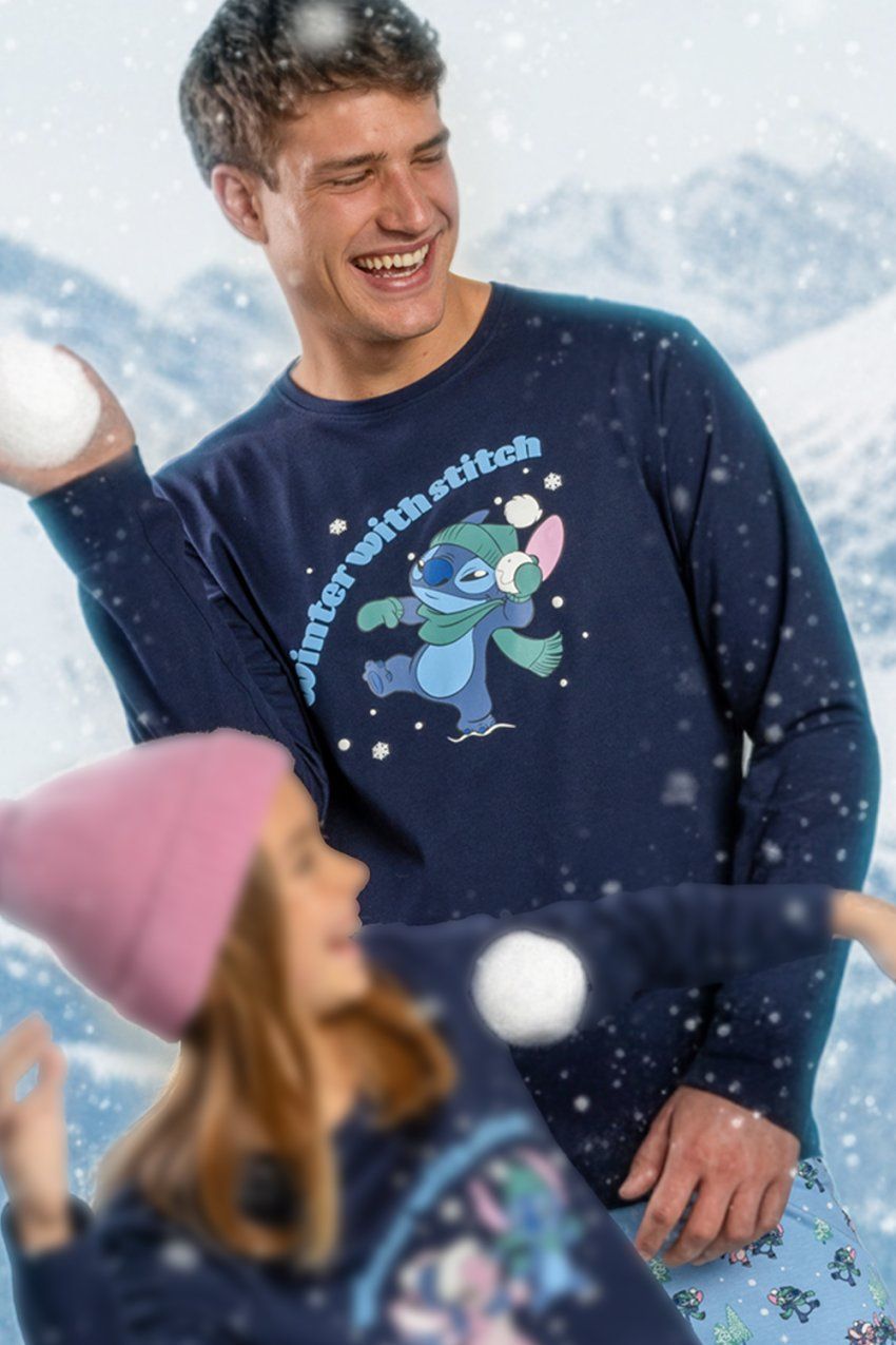 Modelo con pijama de hombre Disney Winter With Stitch 64908, con camiseta azul marino de manga larga con dibujo de Stitch y pantalón estampado.