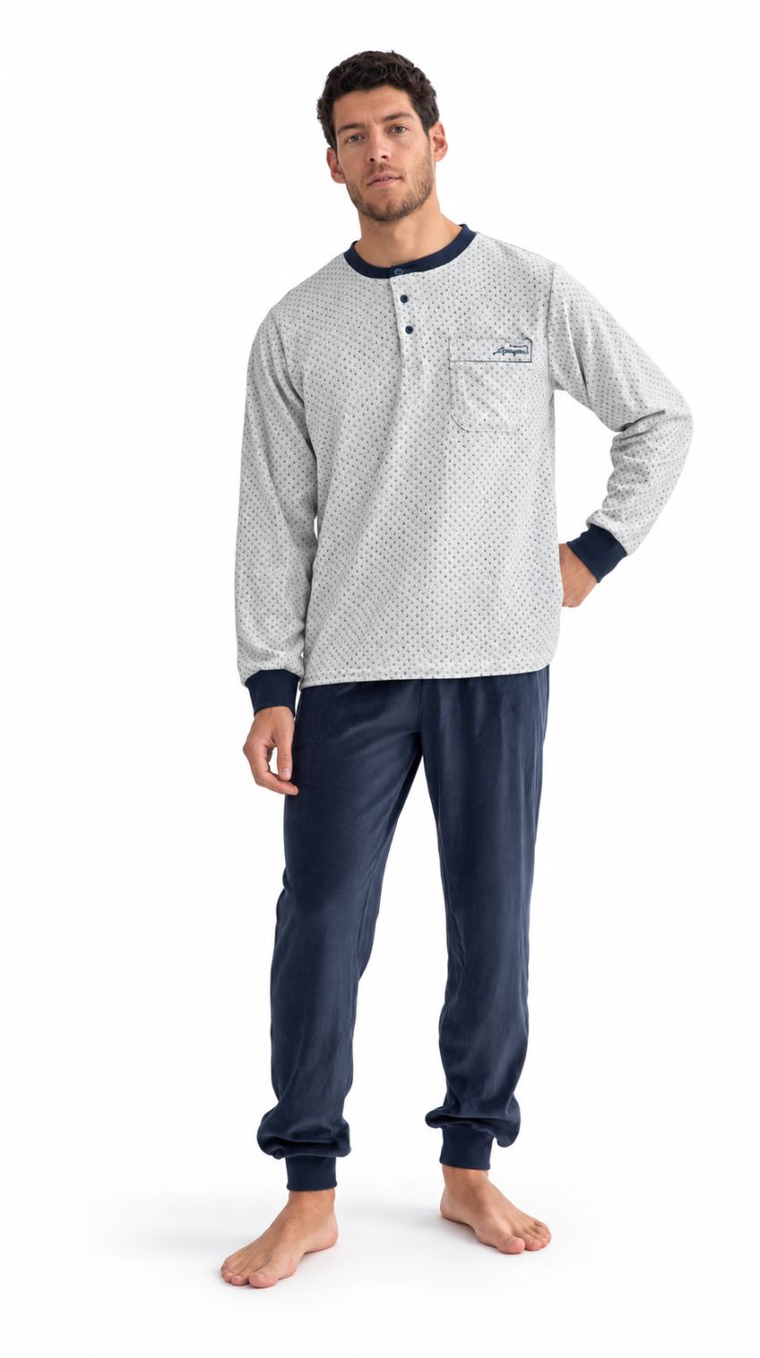 Modelo con pijama de hombre de camiseta gris claro con microestampado, botones y bolsillo en el pecho, y pantalón azul marino con puños.