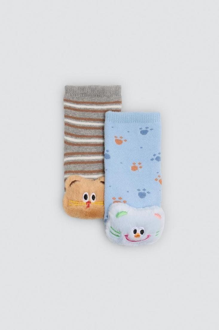 Detalle de calcetines de bebé Ysabel Mora 52905 con rayas grises y marrones, carita de animal de pelo en la puntera y puntos antideslizantes en la suela.