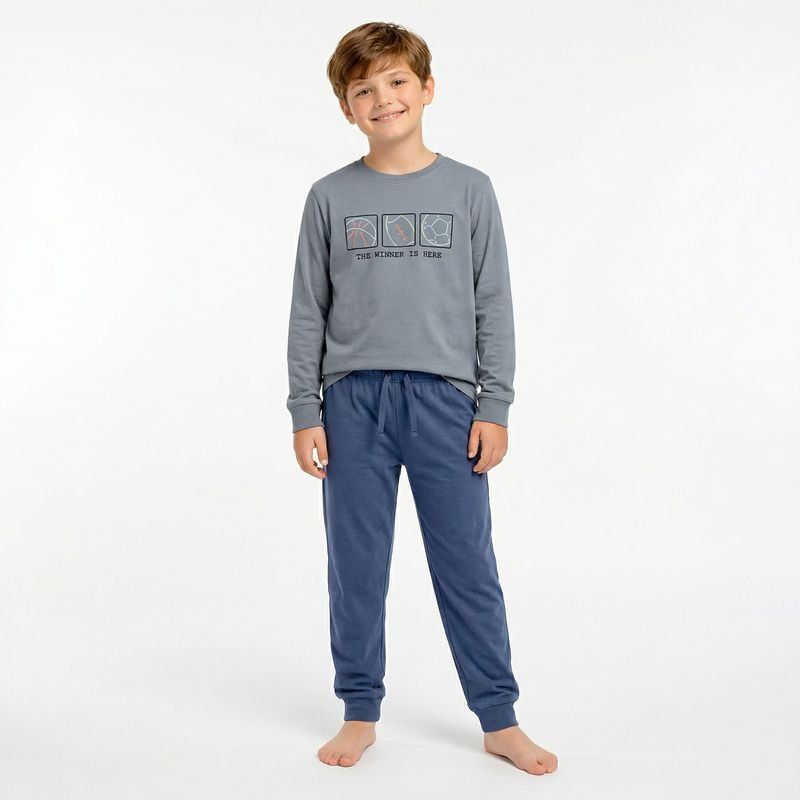 Pijama de niño Katuco con camiseta gris de manga larga y estampado deportivo, combinado con pantalón largo azul con puños.